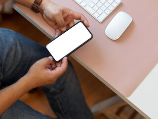 Male office worker hands using smartphone while working at computer desk, clipping path