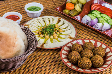 plate of hummus with vegetables and falafel 