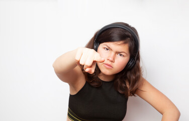 Angry teenage girl standing isolated against white background and looking into the camera