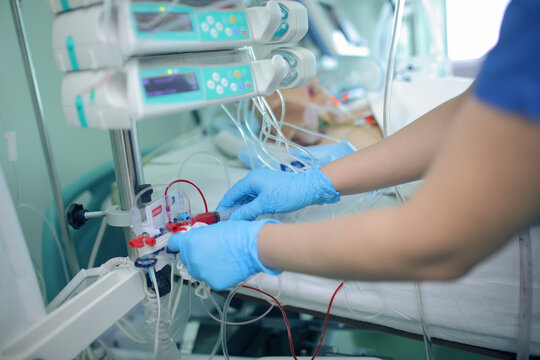 Nursing staff work with the patient's invasive arterial line