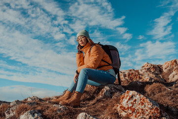 Freedom traveler woman sitting on the top of mountains and enjoy a wonderful nature. Yound girl on peak mountain with perfect view snowy mountains. travel concept