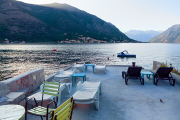 Sun loungers on a private dock with terrace . Morning scenery  of Mountains and Kotor Bay 