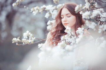 happy girl dreaming in a blooming garden, fresh tenderness spring woman in flowers