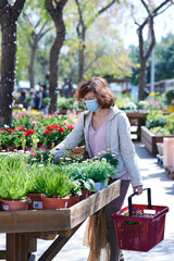 Woman with face mask in a garden shop