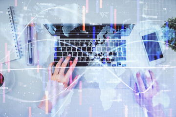 Fototapeta premium Double exposure of woman hands working on computer and financial theme hologram drawing. Top View. Business concept.