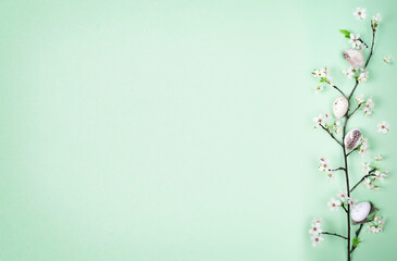 Easter eggs and spring flowers on a green background with copy space. Spring concept