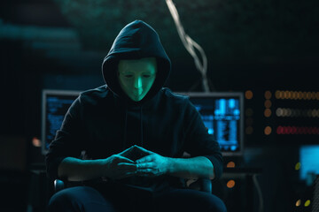 Close-up Shot of Masked Anonymous Hacker Organizes malware Attack on Global Scale. He is in...