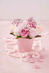 Festive composition with beautiful delicate roses flowers in pink round box on light pink background. Happy Mothers Day Greeting card. Flat lay, copy space.