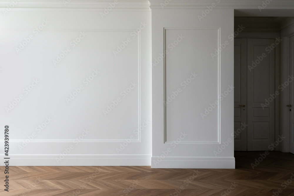 Wall mural Fragment of classic interior with herringbone parquet floor and wall panels with installed moldings and skirting boards. White wall with copyspace.