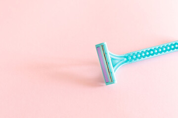 blue plastic lady razor on pink background