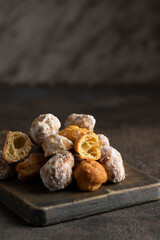 Small  deep fried doughs on wooden cut board. Banuelos, sweets made from wheat , sugar and spices.