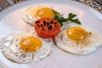 Fried eggs with tomato and herbs