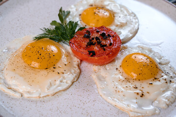 Fried eggs with tomato and herbs