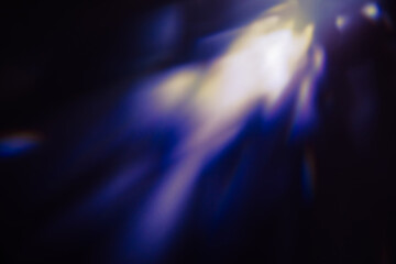 Blur colorful warm rainbow light leaks on black background with dust texture. Defocused abstract...