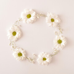 White flowers arranged in a circle on a white background. Spring wedding engagement concept. Flat lay frame.