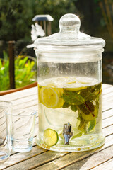 Tap jar with lime and lemon water in a garden