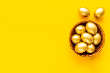 Golden eggs in wooden bowl. Wealth and good luck concept. Easter decoration