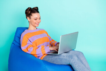 Profile side photo of charming lady hold laptop seat bean bag blogger isolated on teal color background