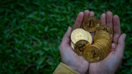 Business concept, a stack of crypto coins in two hands with several Bitcoin coins with a top view.