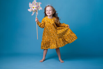 Fototapeta premium little girl holds a windmill in her hands