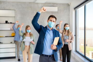 Happy business people wearing masks working in office