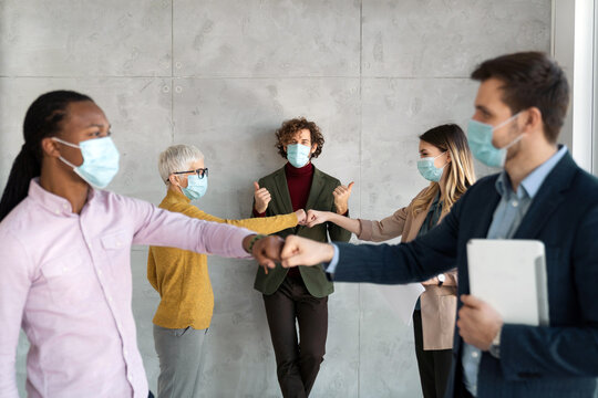 Business People Wearing Masks And Social Distancing In Office