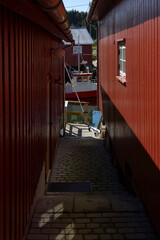 Fishing boats at the pier on a sunny day. Marina in a small fishing village with beautiful houses.