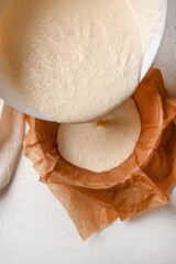 Cooking process Basque burnt cheesecake. The dough is poured into a baking dish covered with paper....