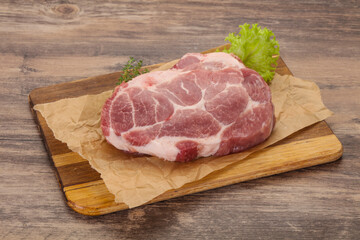 Raw pork steak over wooden board