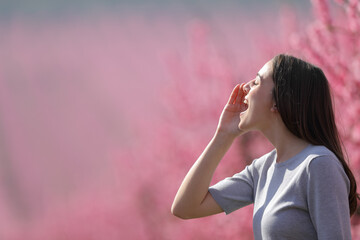 Woman shouting in a field in spring season