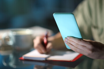 Woman hands checking phone agenda and taking notes