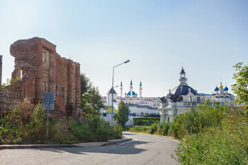 Fototapeta na wymiar Street of Kazan with ruined wall of old building behind Palace of Farmers. Kremlin is on background. Shot in Kazan, Russia
