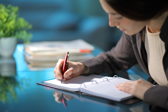 Woman Taking Notes On Notebook In The Night At Home