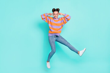 Full length body size view of lovely trendy cheerful girl jumping showing v-sign having fun isolated over bright teal turquoise color background