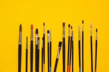 Paint brushes with a palette, brushes on a colored background