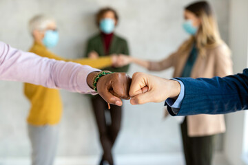 Successful business people wearing masks and greeting to each other in a safe way