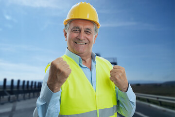 Happy male constructor making celebrating gesture with fists