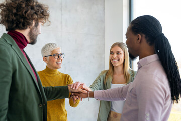 Obraz premium Group of business people with hands together in office. Teamwork success concept