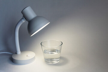 minimalism. the lamp shines on a glass of water
