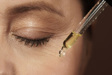 Female eye and dropper with rejuvenating serum