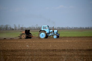 Rural business,tractor in field cultivates soil. Farming in spring
