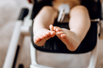 Close-up of little baby feet on highchair