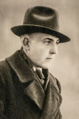 Germany - CIRCA 1930s: Man wearing coat and hat portrait in studio art deco era Vintage photo. Close up