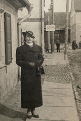 Germany - CIRCA 1930s: Lady wearing coat and hat portrait. Female standing on the street. Woman outdoors. Vintage Carte de Viste Art Deco era photo