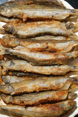 Pan fried fish on a plate. Small crispy fish. Selective focus