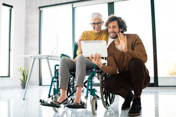 Business people with disability in whellchair working together in office