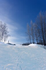 Row of footprints down a mountain slope covered in fresh white snow