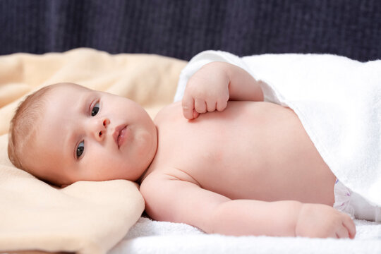 Closeup image of Cute Newborn Baby Boy On White Blanket.