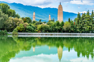 View of Dali Three Pagodas of Chongsheng Temple with water reflection and blue sky Dali Yunnan China