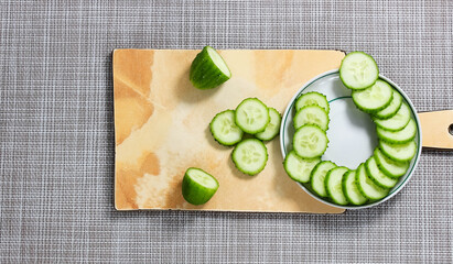 Slice the fresh cucumber on a cutting board and place on a plate.
